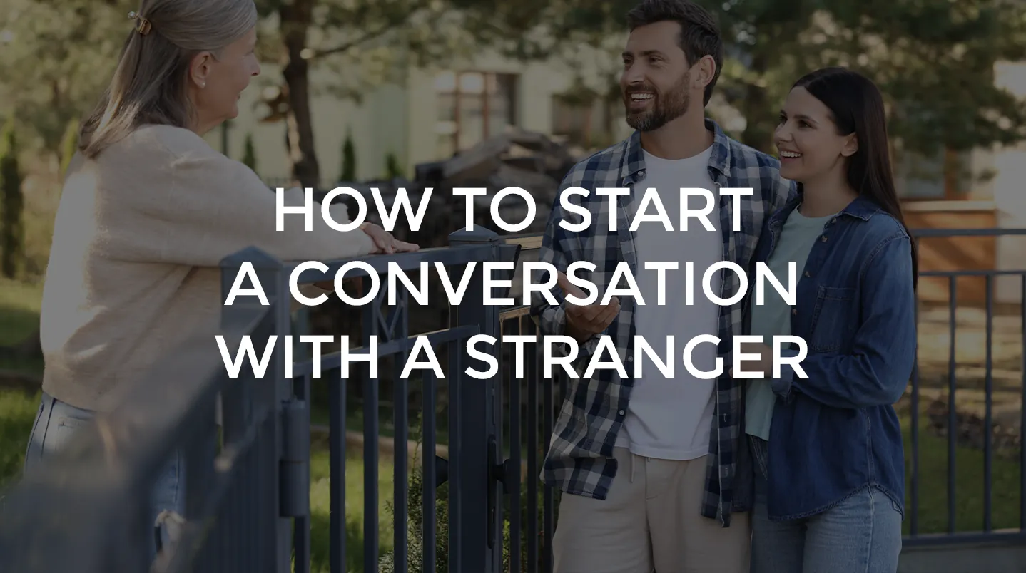 A neighbor talking with a smiling couple over a garden fence