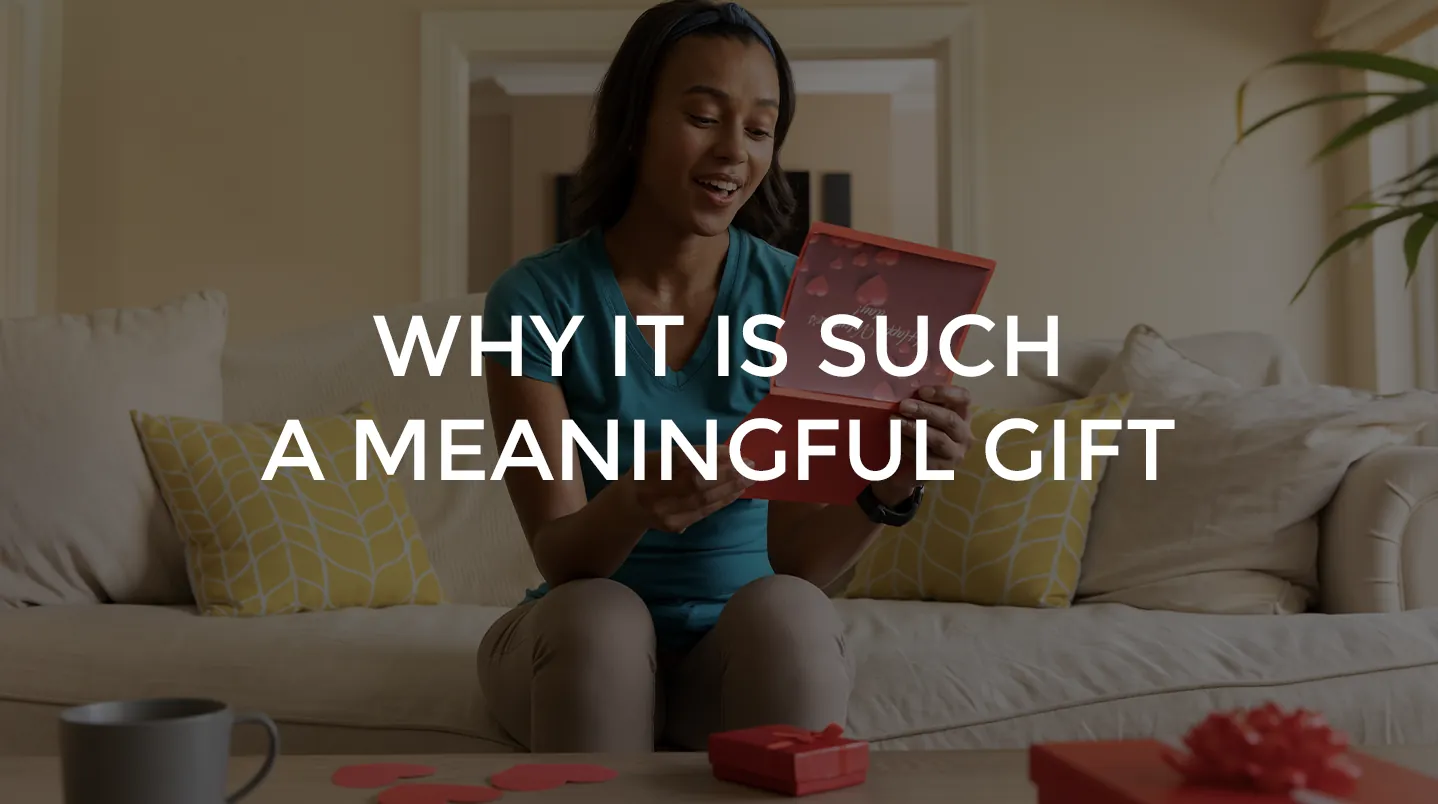 A woman smiling as she opens a card at home