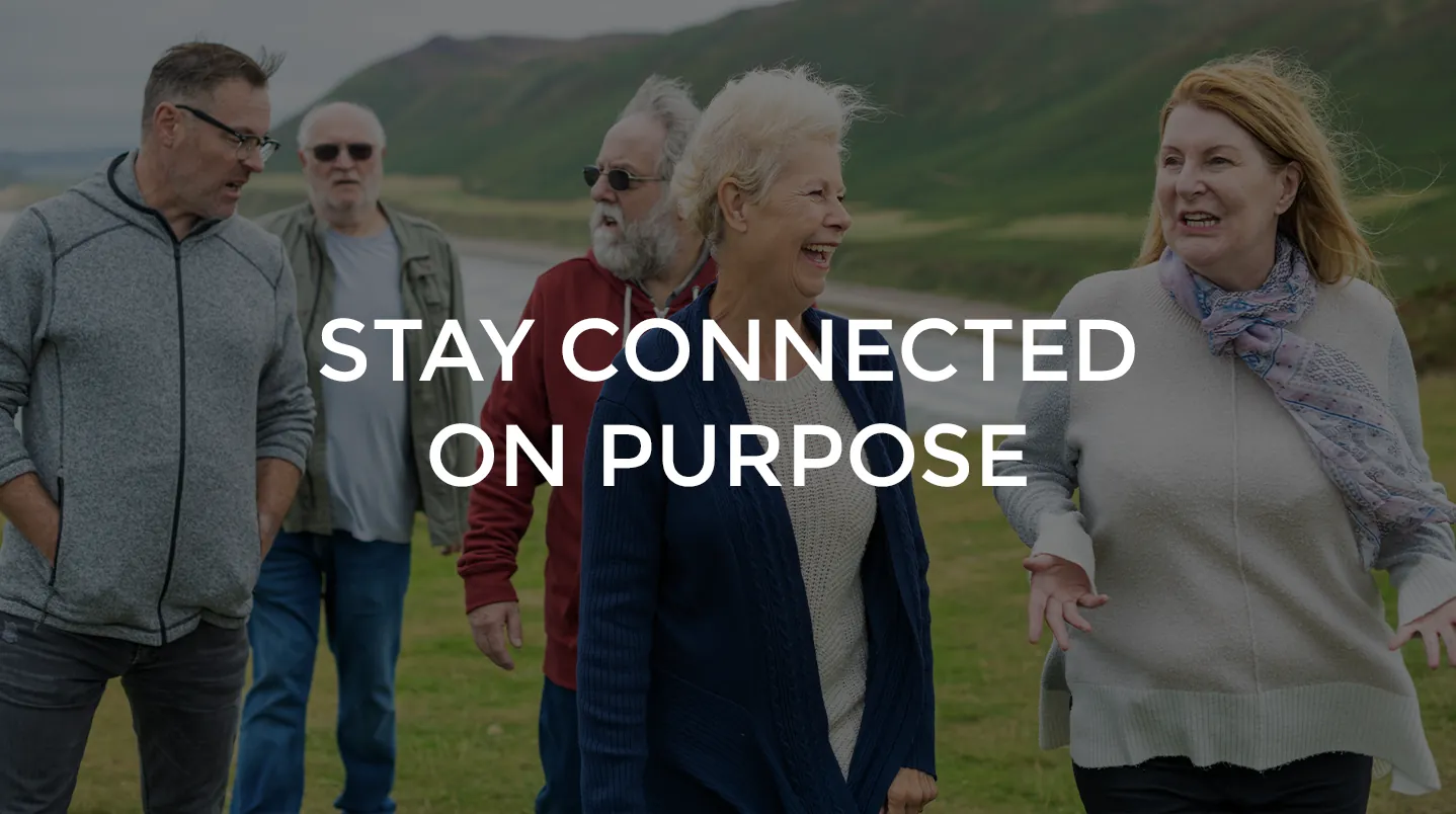 A group of older friends walking and laughing outdoors