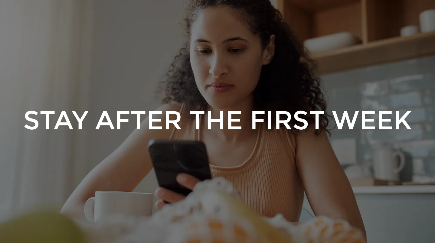 A woman checking her phone at a kitchen table