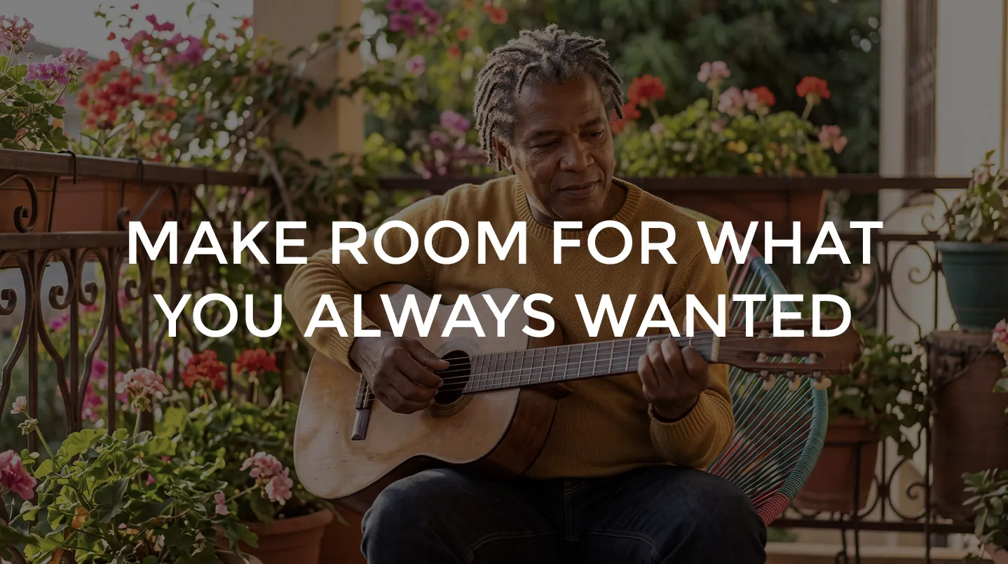 A man playing guitar on a balcony full of flowers