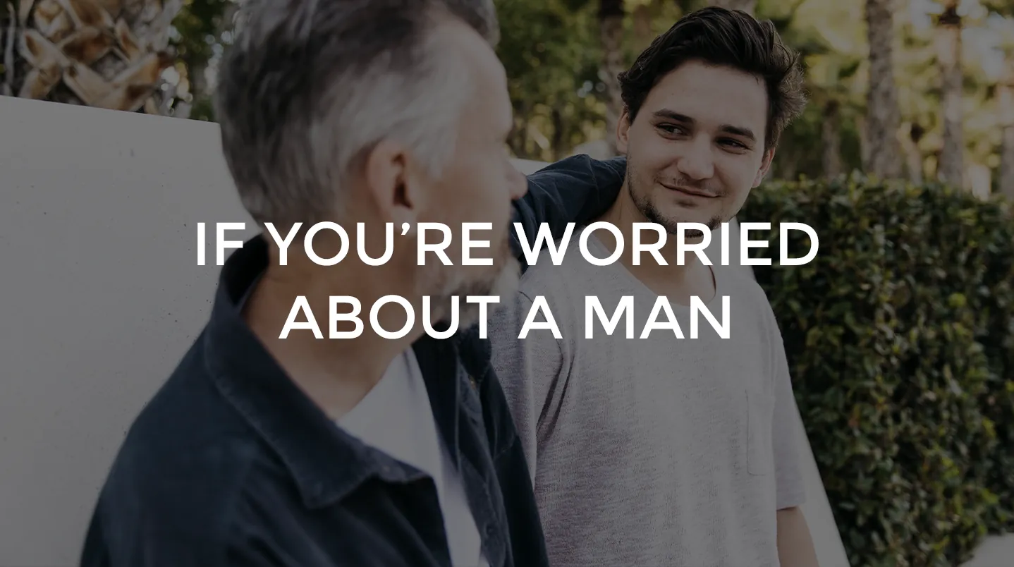 An older man talking with a younger man outdoors